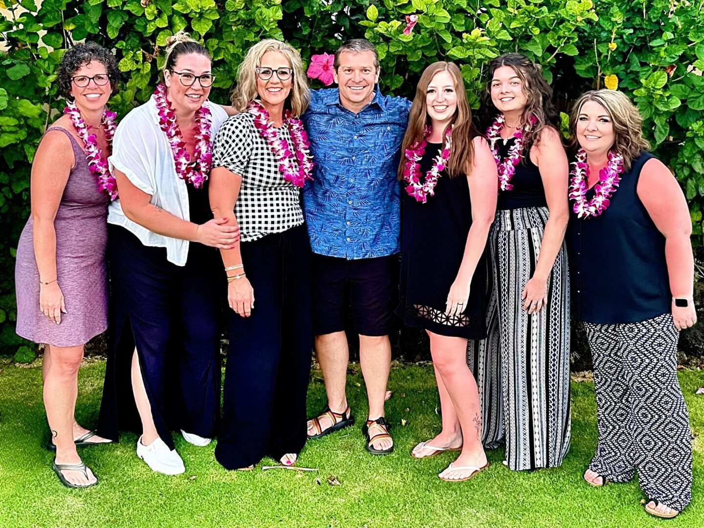 People standing together with floral necklaces