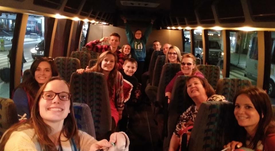 Group smiling inside a bus