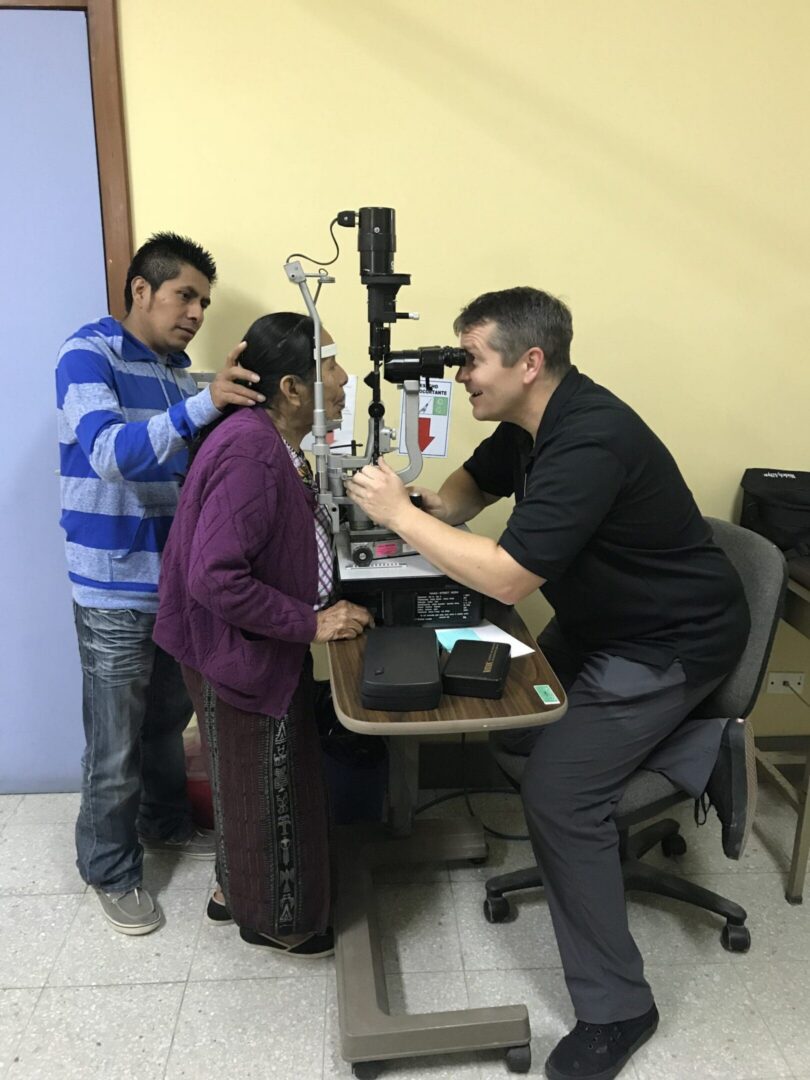 Optometrist conducting eye examination for patient.