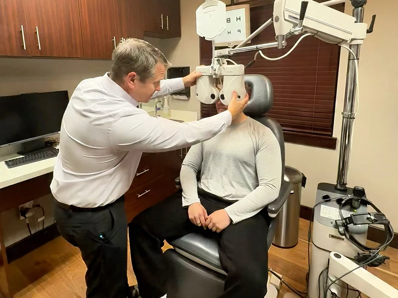 Optometrist adjusting equipment for patient